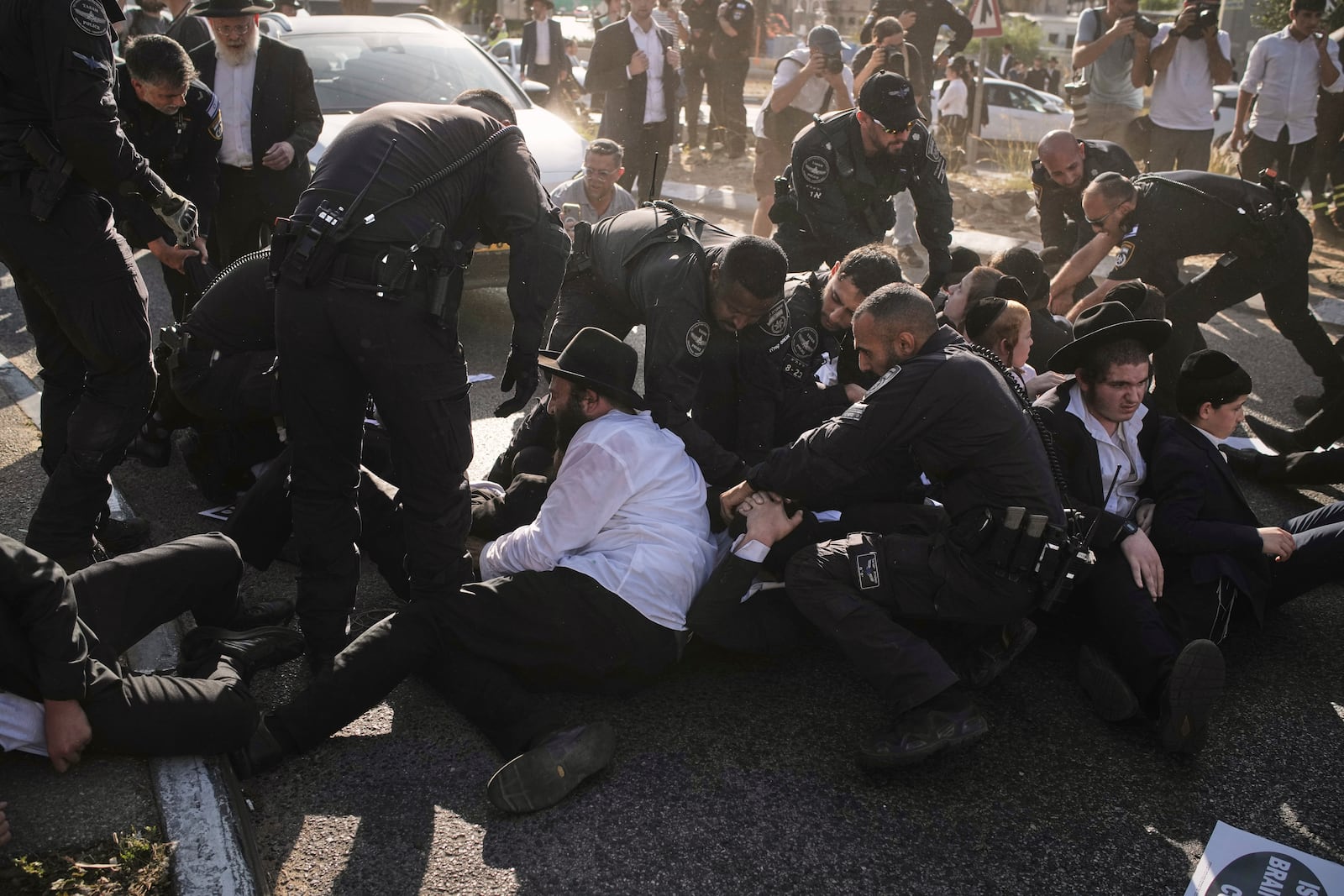 Israeli police officers disperse ultra-Orthodox Jewish men during a protest against army recruitment in Bnei Brak, Israel, Thursday, June 5, 2025. (AP Photo/Leo Correa)