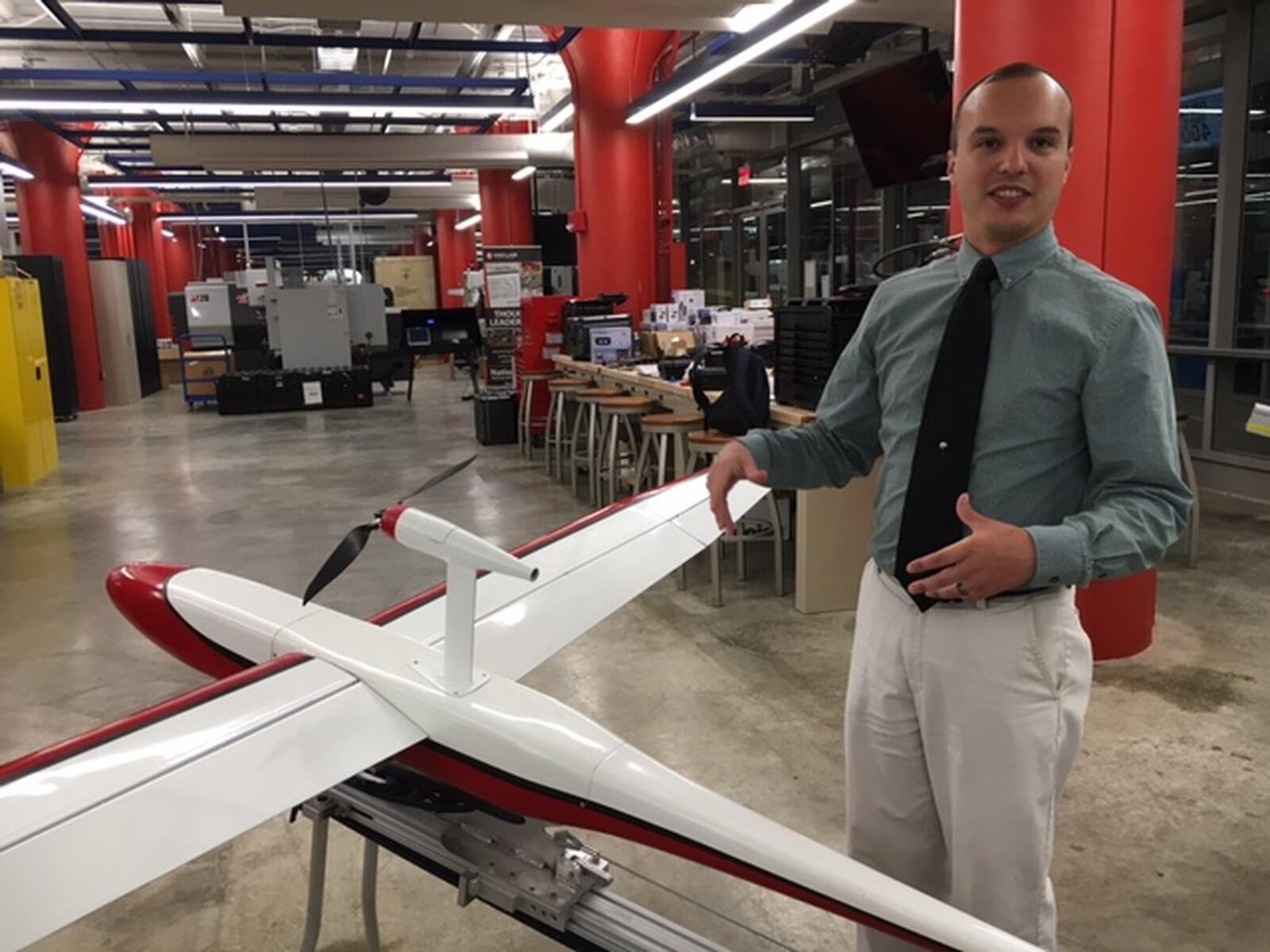 In this file photo, Andrew Shepherd, who heads Sinclair Community College’s unmanned aerial vehicles program, stands next to a version of Unmanned Solutions Technology’s Pelican II fixed-wing UAV. Sinclair is a step closer to offering three bachelor’s degrees, two aviation-related and one in industrial automation. THOMAS GNAU/STAFF ORIGINAL Andrew Shepherd, who heads Sinclair Community College’s unmanned aerial vehicles program, stands next to a version of Unmanned Solutions Technology’s Pelican II fixed-wing UAV in July. THOMAS GNAU/STAFF