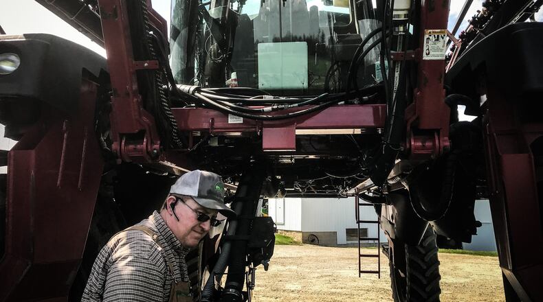 Lane Osswald refills his sprayer on his families 1,500 acre farm in Preble County north of Eaton. He doesn't till the land instead he used cover crops which holds the soil on the land. "When our kids farm in the future, there will be good quality soil left to do that in."