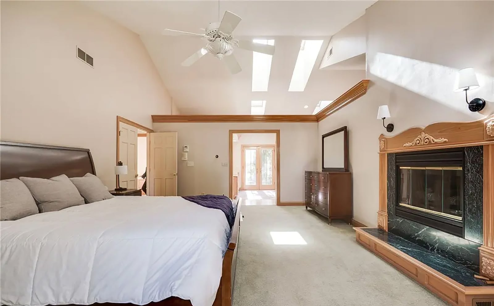 The second floor primary bedroom suite is carpeted and has a vaulted ceiling, fireplace, ceiling fan, skylights and an ensuite bathroom. It also has a private balcony. CONTRIBUTED