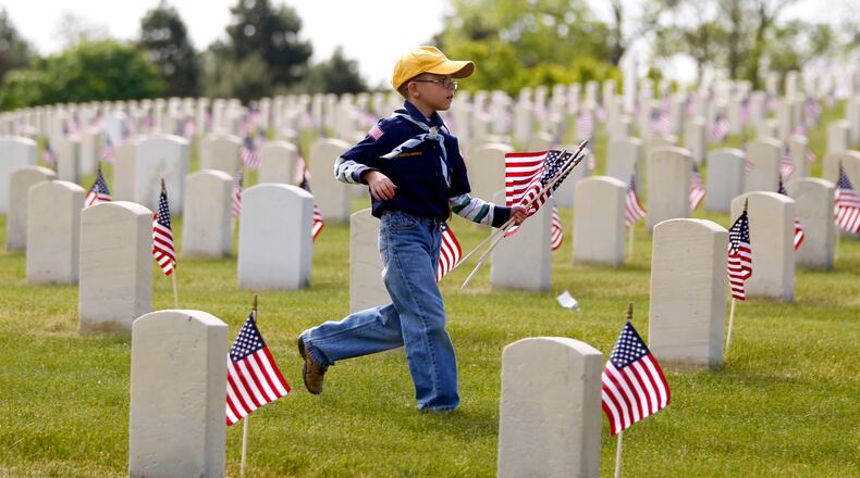 Aaron Forshaw of Englewood, 8, helped plant flags during the Dayton National Cemetery Memorial Day grave decorating ceremony held Saturday. Hundreds of Boy Scouts and Girl Scouts from the area placed 50,000 American flags on graves. The annual event was organized by the American Legion of Ohio and the Dayton National Cemetery. LISA POWELL / STAFF