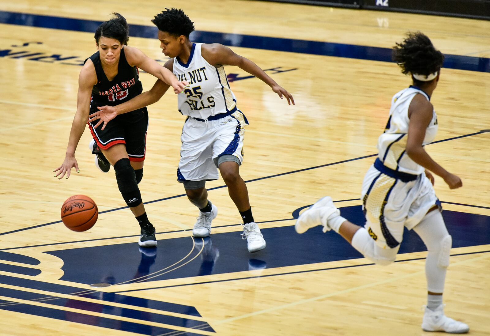 Lakota West's Sarah Jones dribbles the ball while being closely defended by Walnut Hills' Darian Burgin during Wednesday night’s Division I regional semifinal at Fairmont’s Trent Arena. NICK GRAHAM/STAFF