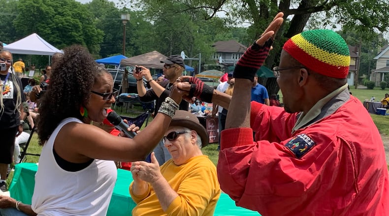 Tiffany Porterfield of the Chazz Band (left) dances with an audience member during the band’s performance at Dayton’s Juneteenth festival. LONDON BISHOP/STAFF