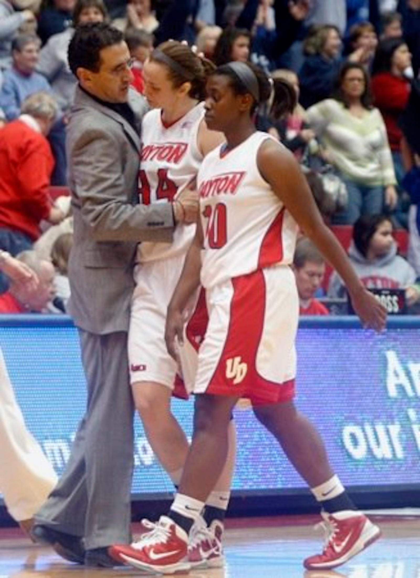 University of Dayton head coach Jim Jabir (from left) consoles player Justine Raterman as she walks with teammate De'Sarae Chambers after the Flyers women fell to the No. 7-ranked Xavier Musketeers 70 to 66 in overtime Saturday, Feb. 5, at UD Arena.
