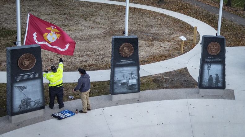 Workers add finishing touches on the new veteran's memorial being unveiled on Saturday Nov. 6, 2021 at Thomas Cloud Park in Huber Heights. JIM NOELKER/STAFF
