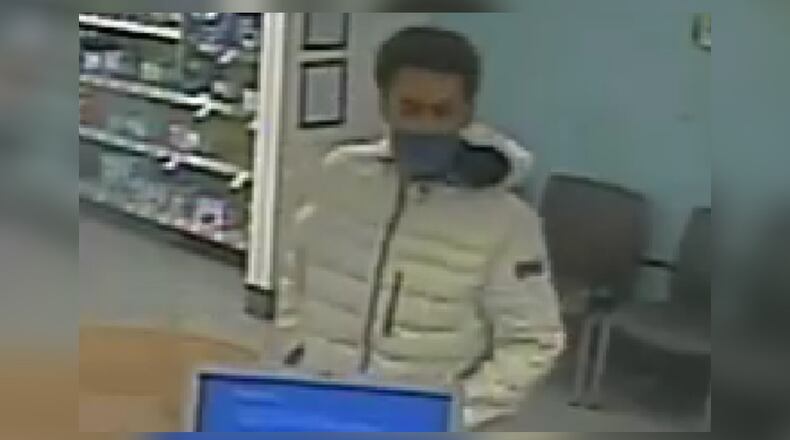Dayton police are asking for the public's help to identify a man with a gun who robbed a Walgreens pharmacy Aug. 9, 2021.
