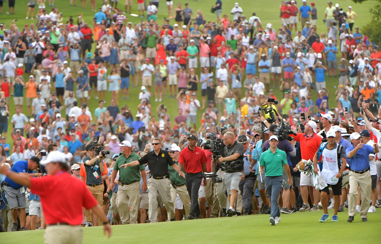 Tiger Woods walks to the 18th green as thousands of fans follow during the final round of the Tour Championship at East Lake Golf Club.  HYOSUB SHIN / HSHIN@AJC.COM