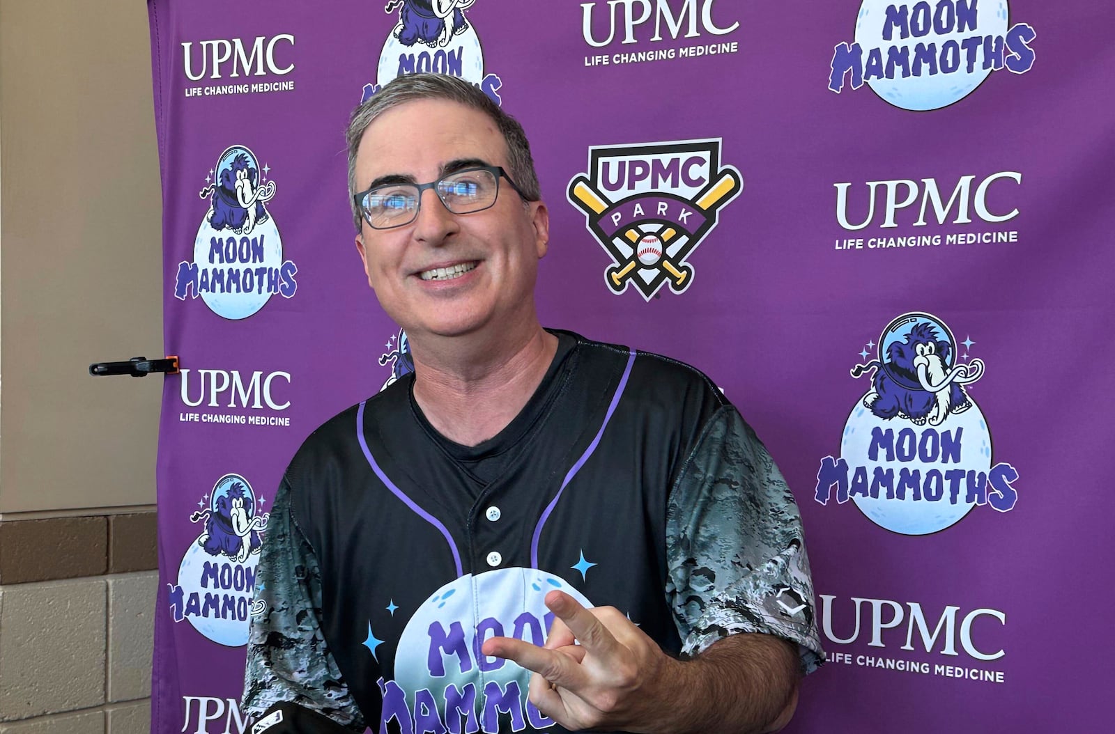 John Oliver speaks to media before a baseball game between the Chesapeake Oyster Catchers and the Erie Moon Mammoths at UMPC Park in Erie, Pa., on Saturday, July 19, 2025. (AP Photo/Joe Reedy)