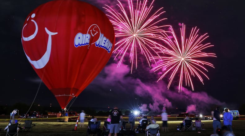 Opening day of The Ohio Challenge hot air balloon festival featured s balloon glow, fireworks and skydivers from Team Fastrax, craft vendors, food and more Friday night, July 15, 2022 at Smith Park in Middletown. Sean Askren's Airheads balloon was inflated and glowed during the fireworks. NICK GRAHAM/STAFF
