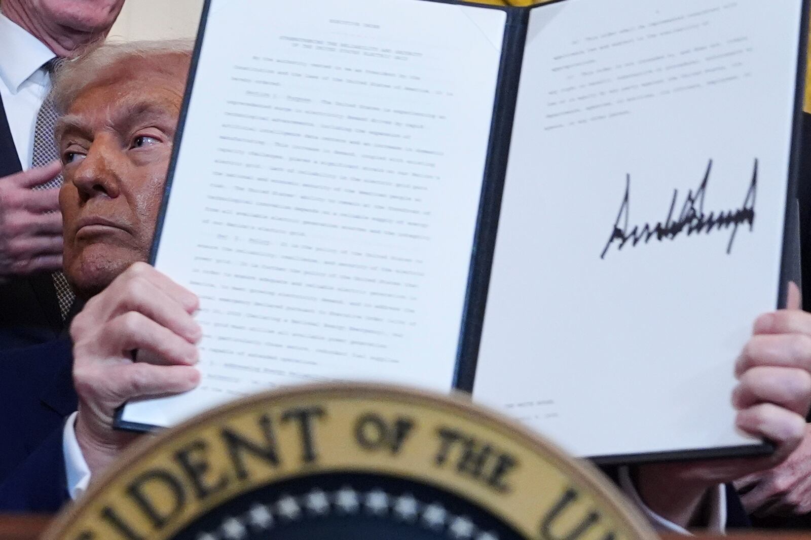 President Donald Trump holds a signed an executive order during an event in the East Room of the White House, Tuesday, April 8, 2025, in Washington. (AP Photo/Evan Vucci)
