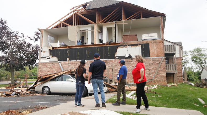 From left, Malyssa Suarez and Steve Cooper, both with the Federal Emergency Management Agency, Ahmed Hossain, of the Small Business Administration, and Brigitte Bouska, with the Ohio Emergency Management Agency, conduct a joint preliminary assessment of tornado-damaged buildings Wednesday at the Woodland Hills Apartments in Trotwood. CHRIS STEWART / STAFF