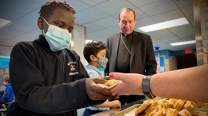 Archbishop of Cincinnati Dennis M. Schnurr, shares baked treats Tuesday, March 1, 2022 before lent with students at the Our Lady of the Rosary Elementary School. MARSHALL GORBY\STAFF