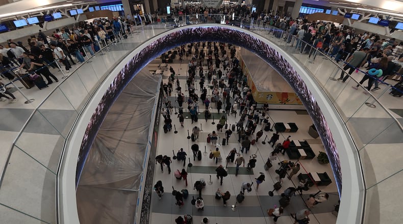 Travelers line up at a TSA checkpoint at George Bush Intercontinental Airport in Houston, Thursday, March 26, 2026. (AP Photo/Lekan Oyekanmi)