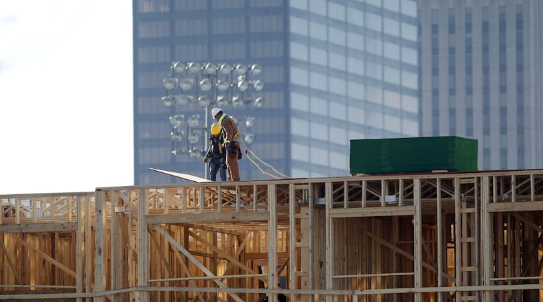 Workers build out the Centerfield Flats on East First Street next to Fifth Third Field in downtown Dayton. The 112 unit apartments are expected to open in the summer of 2019. TY GREENLEES / STAFF