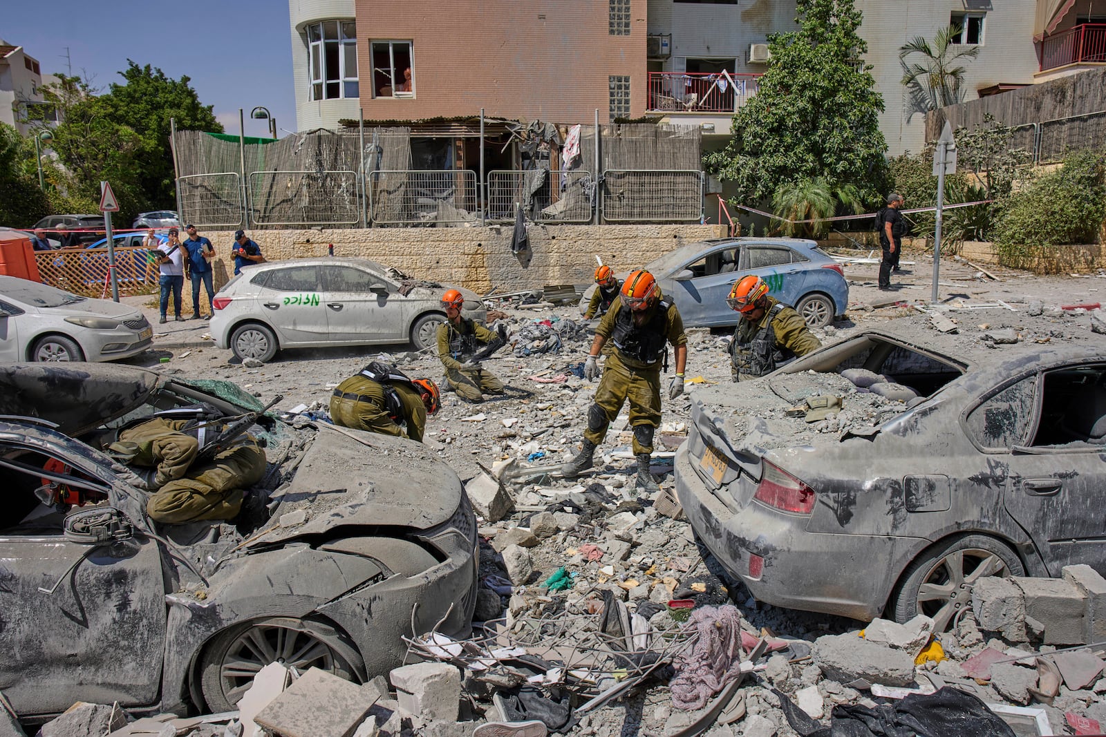 Israeli soldiers work amid the rubble of residential buildings destroyed by an Iranian missile strike that killed several people, in Beersheba, Israel, on Tuesday, June 24, 2025. (AP Photo/Bernat Armangue)