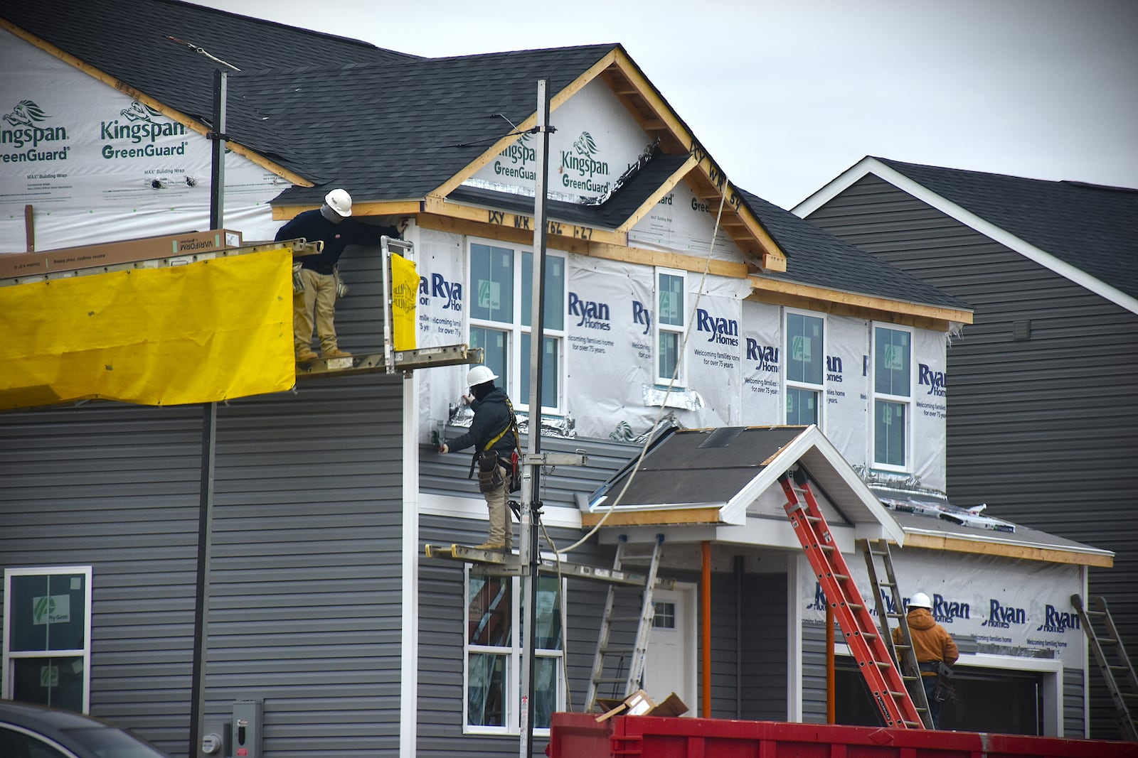 Construction crews work on the outside of a new Ryan Homes house in the Willow Hills subdivision in northeast Dayton. CORNELIUS FROLIK / STAFF