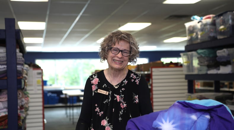 Volunteer Mary Jo Padderud works in HTC's linens department sorting donated towels and bedding.