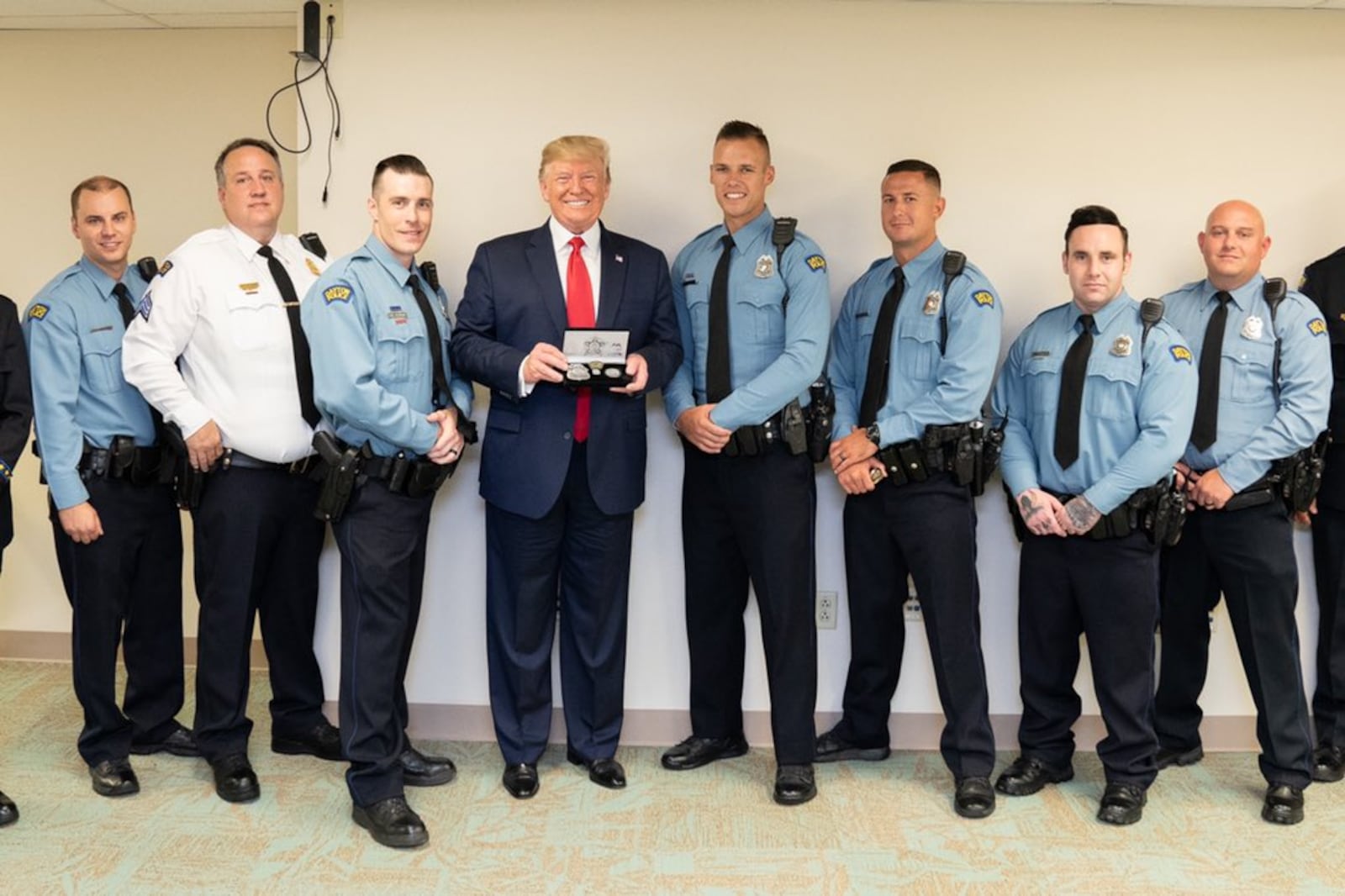 President Donald Trump is shown with Dayton police officers who helped stop the gunman in the Oregon District mass shooting on Aug. 4, 2019. From left, Brian Rolfes, Sgt. Chad Knight, David Denlinger, Vincent Carter, Jeremy Campbell, Ryan Nabel and Jason Berger. Trump visited Dayton days after the shooting to meet with first-responders and victims from the deadly shooting. WHITE HOUSE PHOTO