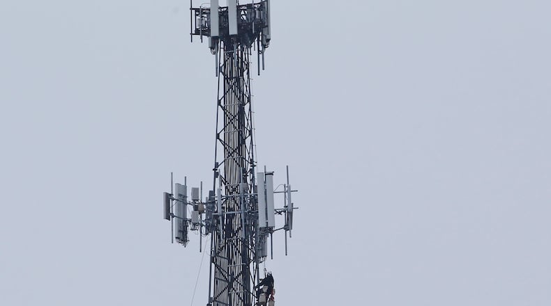 Communication workers recently were hoisted to the top of a cell tower along U.S. 35 in Beavercreek. This tower has multiple carriers’ antennae and reaches nearly 300-feet tall. TY GREENLEES / STAFF