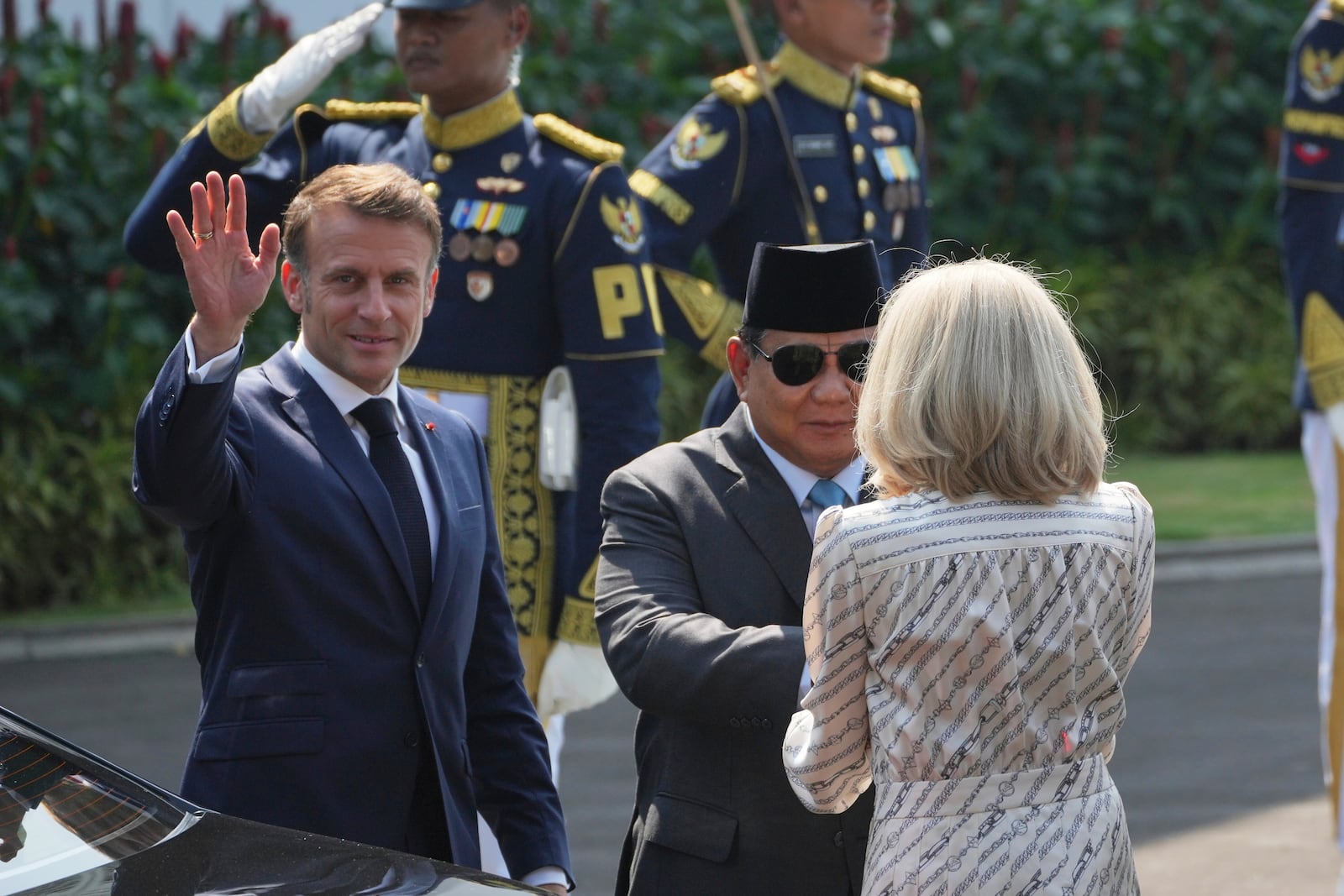 Indonesian President Prabowo Subianto, center, shakes hands with French first lady Brigitte Macron as French President Emmanuel Macron waves before their meeting at Merdeka Palace in Jakarta, Indonesia, Wednesday, May 28, 2025. (AP Photo/Achmad Ibrahim)