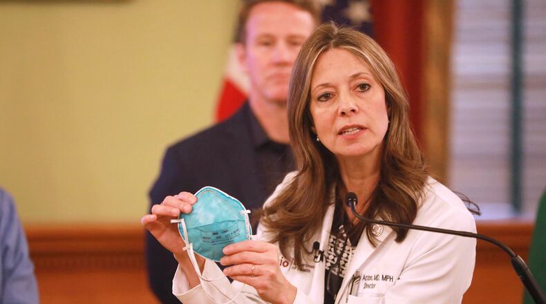 Ohio Department of Health Director Dr. Amy Acton holds a mask at a coronavirus news conference March 14, 2020, at the Ohio Statehouse in Columbus. (Doral Chenoweth/The Columbus Dispatch via AP)