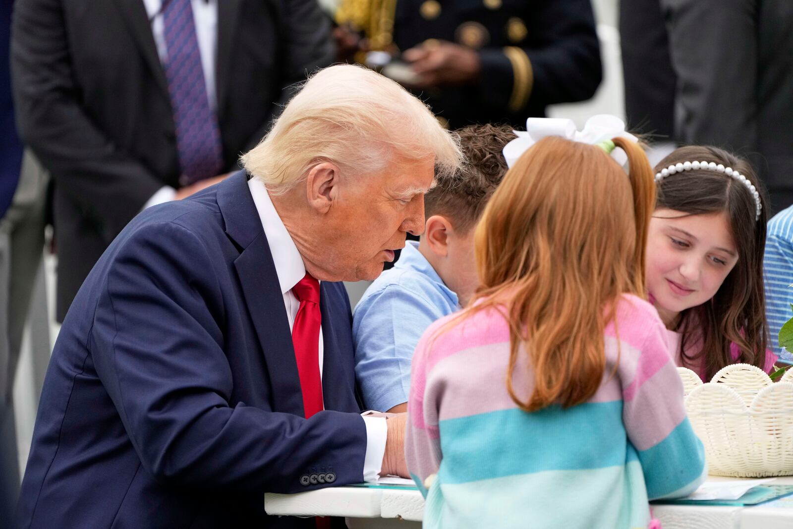 President Donald Trump sits with children as he participates in the White House Easter Egg Roll on the South Lawn of the White House, Monday, April 21, 2025, in Washington. (AP Photo/Mark Schiefelbein)