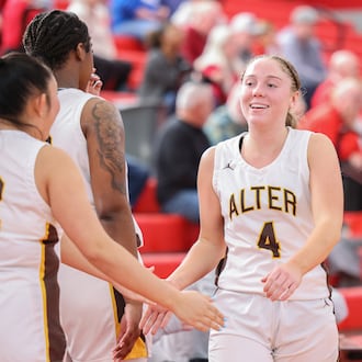 Alter senior guard Alison Link claps hands with teammates after returning to the bench late in a 40-29 win over Cincinnati Indian Hill on Saturday, Feb. 28 at Troy High School's Trojan Activities Center. BRYANT BILLING / STAFF