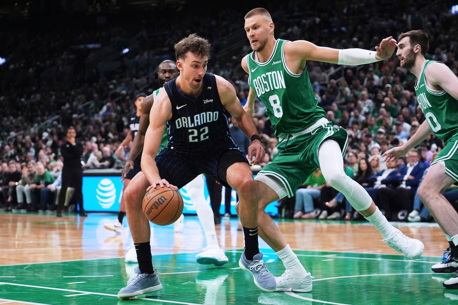 Orlando Magic forward Franz Wagner (22) drives to the basket against Boston Celtics center Kristaps Porzingis (8) during the first half in game 2 of a first-round NBA playoff basketball series, Wednesday, April 23, 2025, in Boston. (AP Photo/Charles Krupa)
