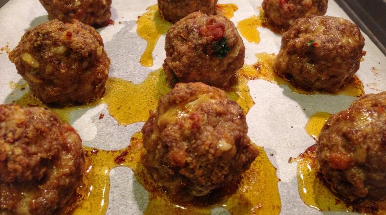 Be sure to use parchment paper in the pan when you bake these Smokn’ Bacon Balls; otherwise, they’ll drip all over the place because they’re loaded with bacon lardons, ground chuck, heavy cream and smoked cheddar. (CONNIE POST/STAFF PHOTO)