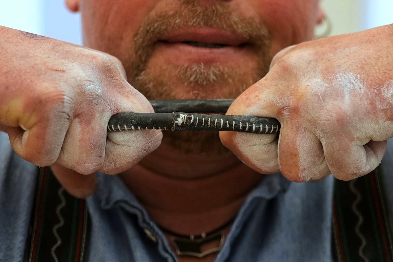 A competitor warms up for his bout while he try to pull the opponent over the table at the German Championships in Fingerhakeln or finger wrestling, in Pang, near Rosenheim, Germany, Sunday, April 27, 2025. (AP Photo/Matthias Schrader)