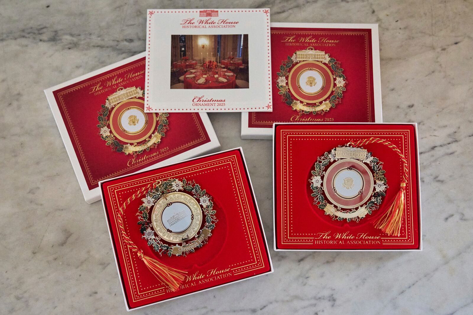 The front and back of the 2025 White House Christmas ornament is pictured with the box and information packet, Thursday, April 10, 2025, at the association in Washington. (AP Photo/Jacquelyn Martin)