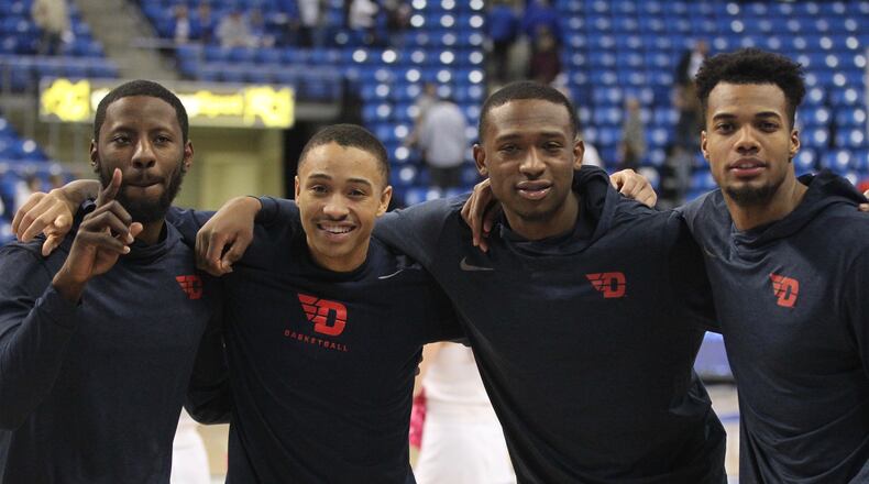 Dayton’s Scoochie Smith, Kyle Davis, Kendall Pollard and Charles Cooke pose for a photo after beating Saint Louis for their 98th career victory  on Feb. 14, 2017, at Chaifetz Arena in St. Louis.