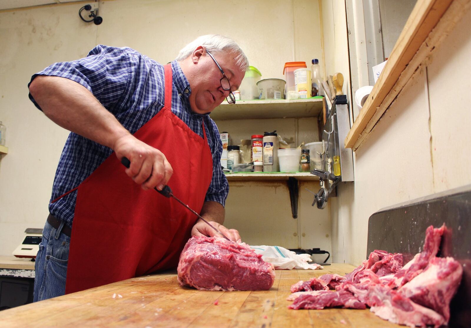 David Hoffer, president of Zinks Meats and Fine Wines, prepares a boneless ribeye in his butcher shop Friday on Marco Lane in Washington Twp.