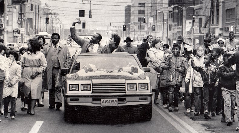 A parade for the two-time Olympic champion was held in downtown Dayton in 1984. Edwin C. Moses and his wife Myrella rode from Courthouse Square to Memorial Hall in a convertible with a patriotic banner covering the hood.More than 1,000 Dayton public school children walked alongside holding American flags high as Moses and his wife waved to the crowd on the streets. DAYTON DAILY NEWS ARCHIVE