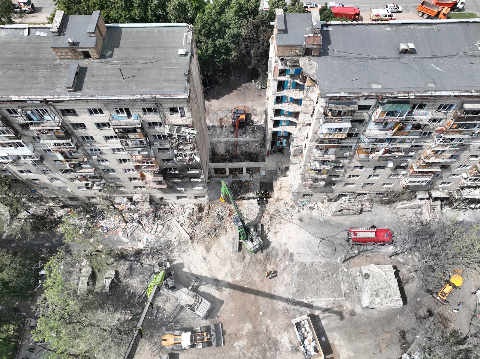 In this aerial photo provided by the Ukrainian Emergency Service, searchers sift through the wreckage on the site of Russia's Tuesday deadly missile attack that ruined a multistory residential building in Kyiv, Ukraine, Wednesday, June 18, 2025. (Ukrainian Emergency Service via AP)