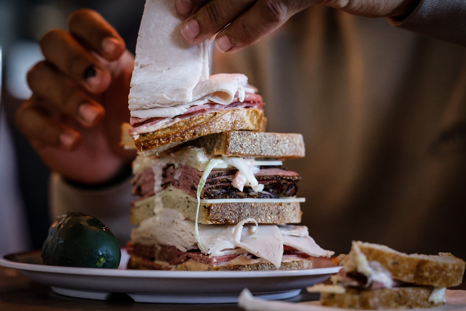 Four members of the Ohio State Buckeyes compete Monday, Oct. 9, 2023, to finish a 2½ pound All the Best Deli sandwich for the Gala of Hope Foundation of Dayton. The foundation received $500. STAFF