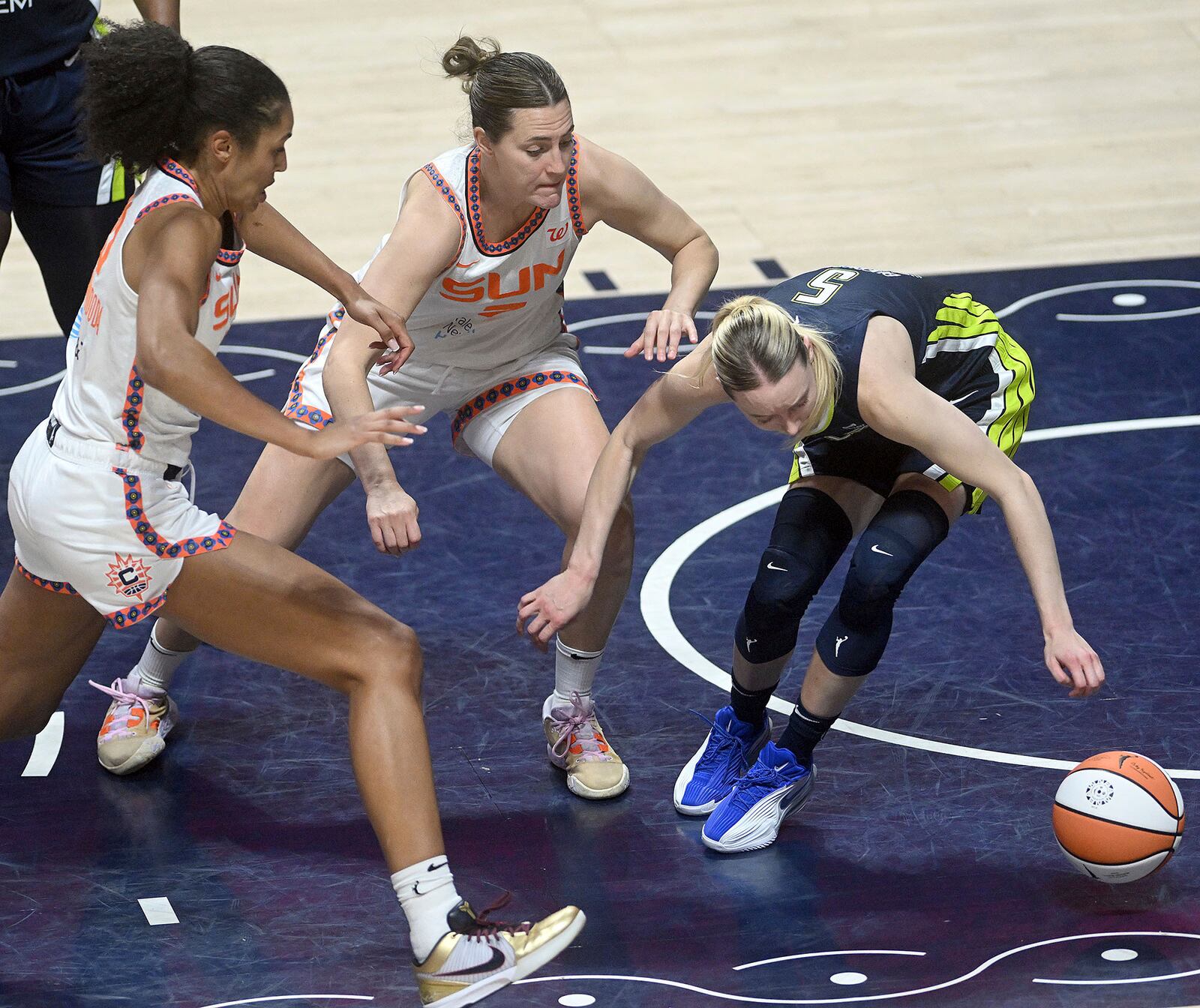Dallas Wing's Paige Bueckers, right, and Connecticut Sun's Haley Peters, center, and Olivia Nelson-Ododa push for a rebound during a WNBA basketball game Tuesday, May 27, 2025, in Uncasville, Conn. (Sarah Gordon/The Day via AP)