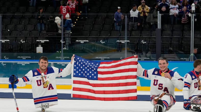 United States's Brody Roybal and his teammate Jack Wallace celebrate on the podium after winning the gold medal at the ice hockey of the 2026 Winter Paralympics, in Milan, Italy, Sunday, March 15, 2026. (AP Photo/Luca Bruno)