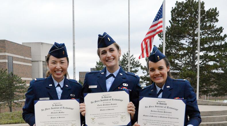 Second Lts. Michelle McGee, Emily Graves and Jordan Peterson display their Master of Science degrees following the March 25 commencement ceremony at the Air Force Institute of Technology. U.S. AIR FORCE PHOTO/KATIE SCOTT