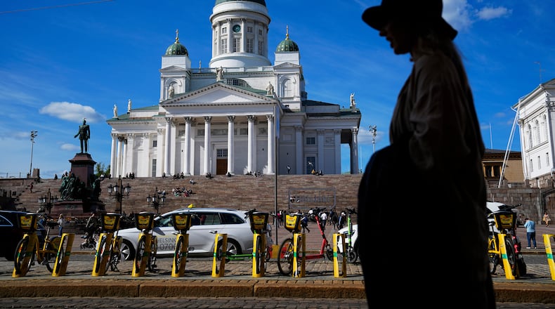 FILE - A woman walks past the Helsinki Cathedral in Helsinki, May 29, 2023. (AP Photo/Pavel Golovkin, File)