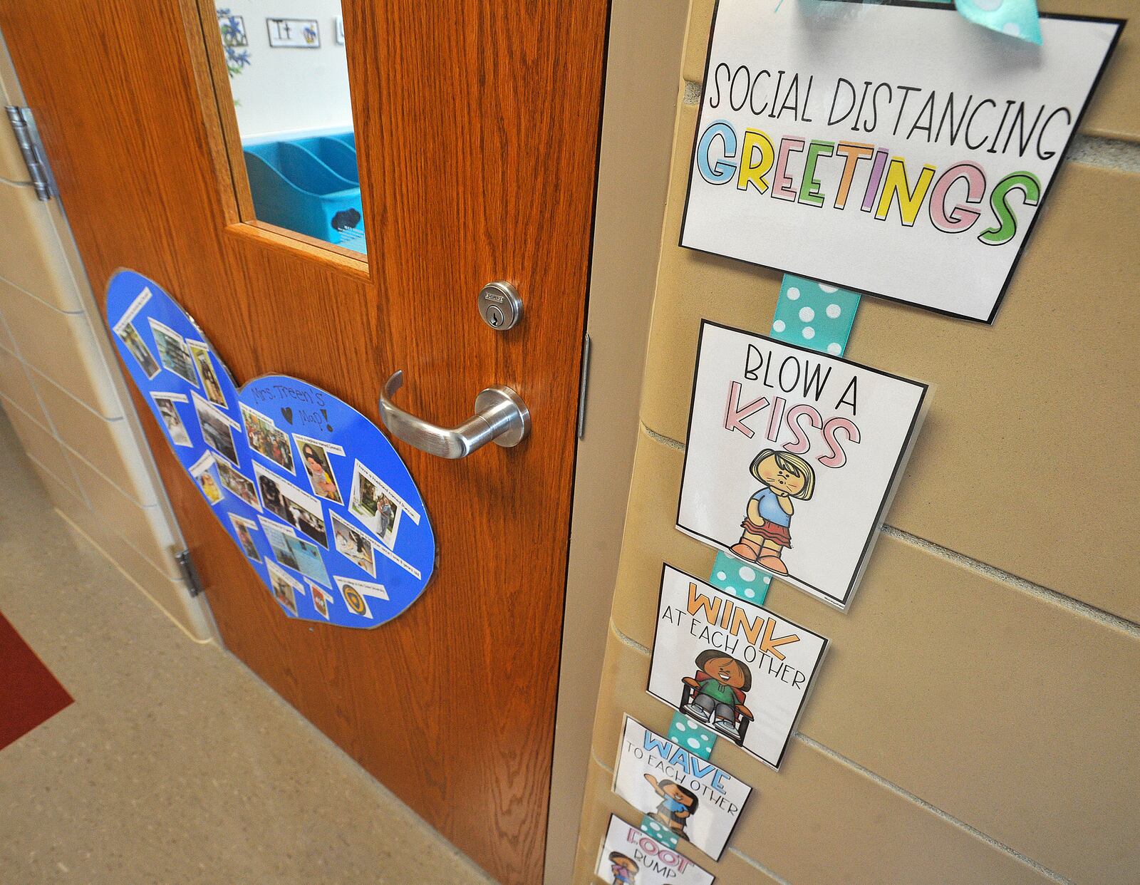 A kindergarden teacher at Orchard Park Elementary, in Kettering, offers different ways to offer social distancing greetings.  MARSHALL GORBY\STAFF