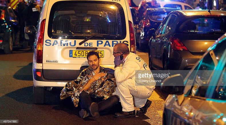 A medic tends to a man after an attack near the Boulevard des Filles-du-Calvaire November 13, 2015 in Paris, France. Gunfire and explosions in multiple locations erupted in the French capital with early casualty reports indicating at least 60 dead. (Getty)