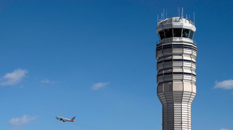 An airplane takes off behind the control tower at Ronald Reagan Washington National Airport, on the anniversary of the Potomac River mid-air collision between an American Airlines passenger plane and an Army Blackhawk helicopter, Thursday, Jan. 29, 2026, in Arlington, Va. (AP Photo/Cliff Owen)