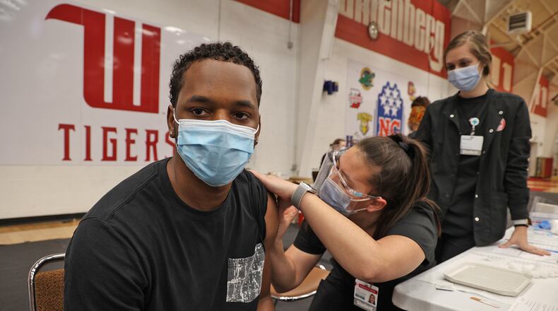 Kris Thompson, a Wittenberg University student, gets a COVID vaccine shot from Wittenberg nursing student Jillian Connelly Thursday in the Pam Evans Smith Arena on campus. BILL LACKEY/STAFF
