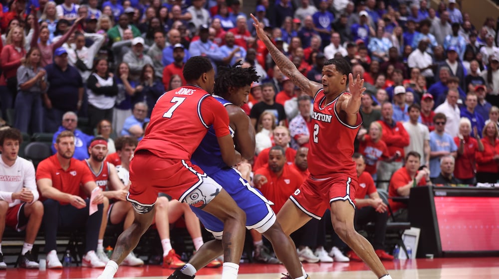 Dayton's De'Shayne Montgomery, left, and Keonte Jones apply defensive pressure in the final minute against Brigham Young on Friday, Nov. 28, 2025, at the State Farm Field House in Kissimmee, Fla. David Jablonski/Staff