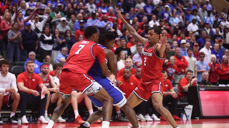 Dayton's De'Shayne Montgomery, left, and Keonte Jones apply defensive pressure in the final minute against Brigham Young on Friday, Nov. 28, 2025, at the State Farm Field House in Kissimmee, Fla. David Jablonski/Staff