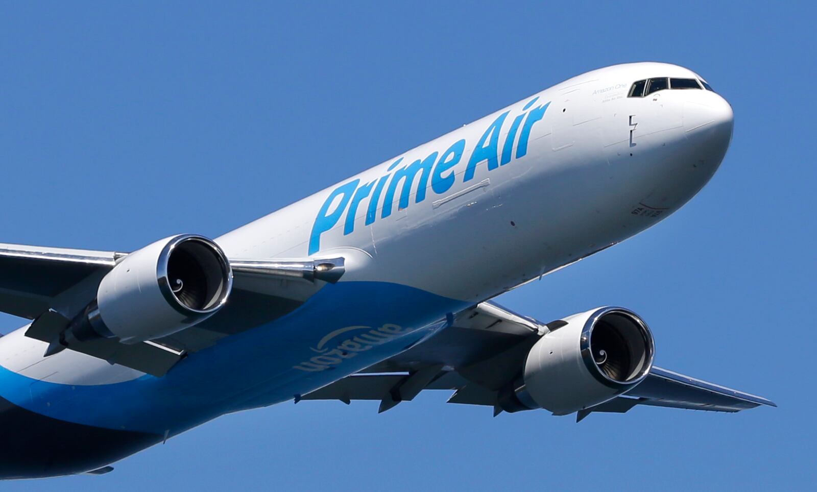 A Boeing 767 with an Amazon.com “Prime Air” livery flies over Lake Washington, Friday, Aug. 5. The plane landed at Wilmington Air Park for the first time Wednesday, Atlas Air Worldwide confirmed Thursday. It is Amazon’s first branded cargo plane. (AP Photo/Ted S. Warren)
