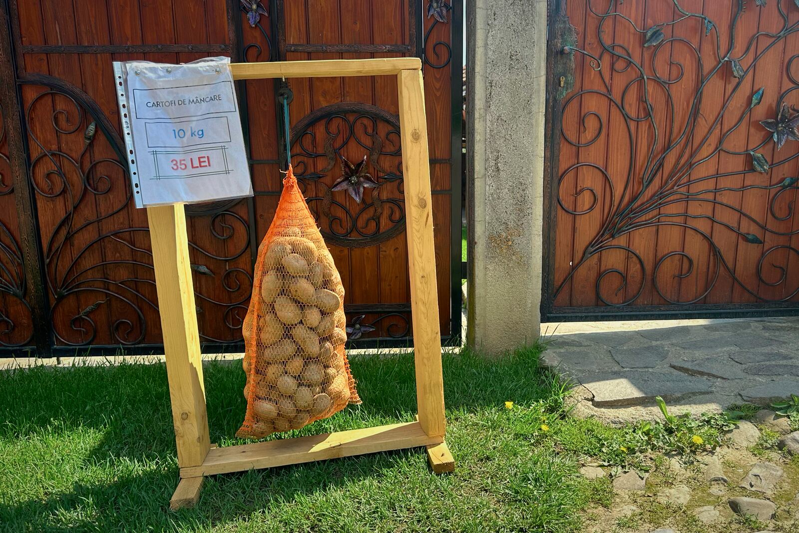 Potatoes on sale hang in a bag outside a house in the village of Saschiz, in Romania's central Transylvania region, Friday, April 25, 2025. (AP Photo/Stephen McGrath)