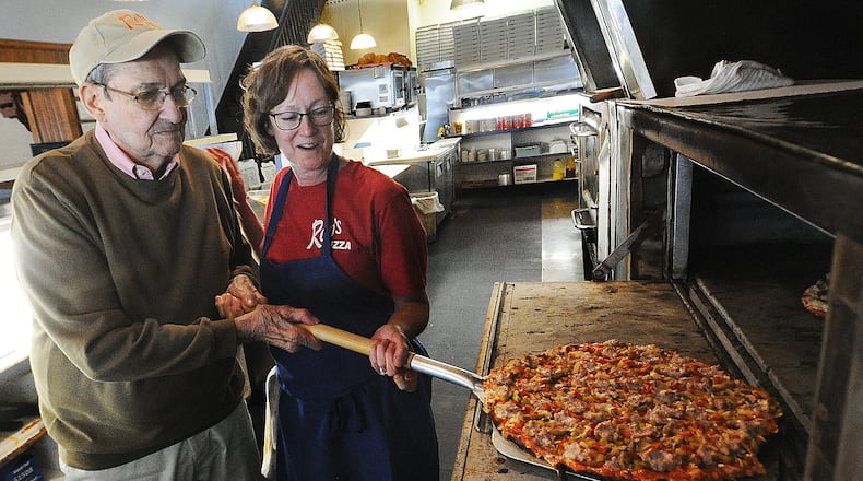 Ron Holp and his daughter, Abbie Romero, remove a pizza from the oven at Ron's Pizza in downtown Miamisburg Thursday, Jan. 5, 2023. The business is in the process of wrapping up remodeling that has taken more than a year. MARSHALL GORBY/STAFF