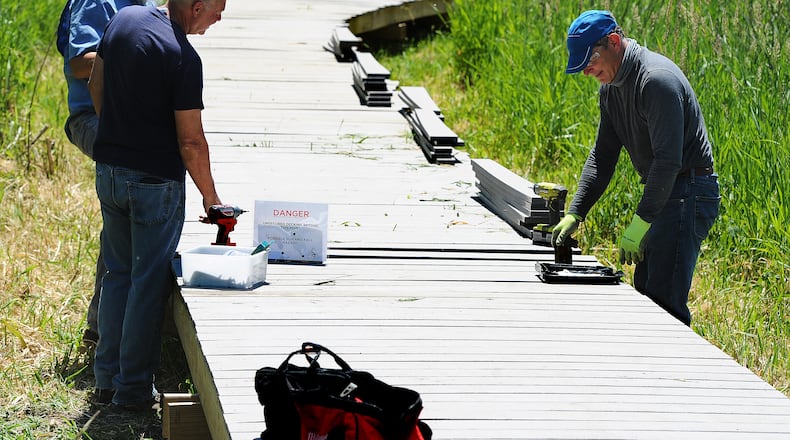 Beavercreek Wetlands Association volunteers Skip Beehler, Ken Moran, and Scott Ley work to build out the boardwalk at Dave Nolin Wetland Reserve, to allow public access to the wetland. MARSHALL GORBY/STAFF